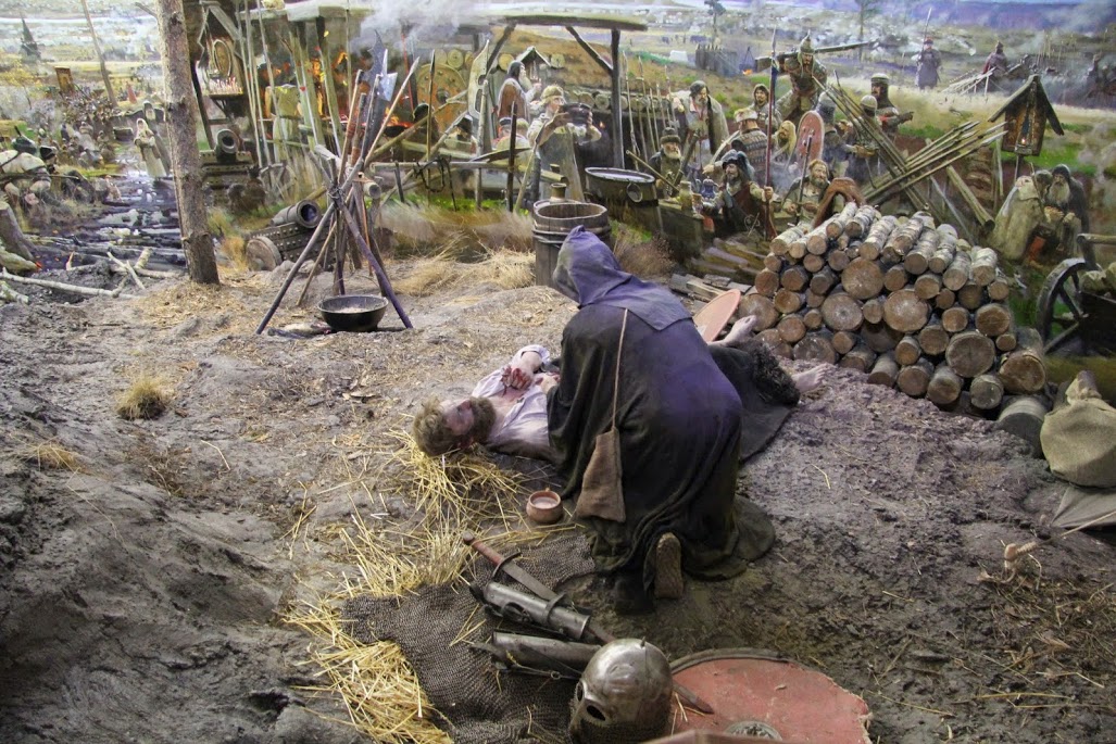 Старец склонился над раненым. В ту пору братья-монахи часто были среди воинов. фото